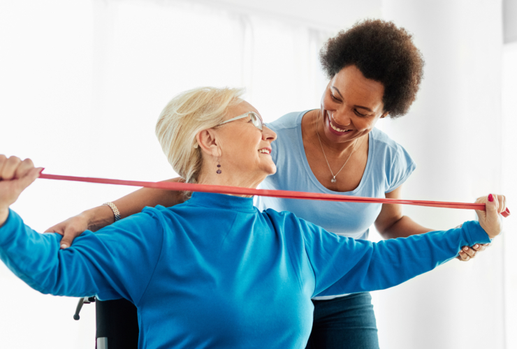 An older woman using medical equipment in physical therapy.